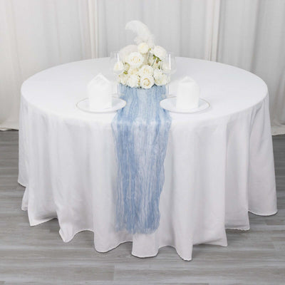 Elegant wedding table setting with white roses and blue runner.