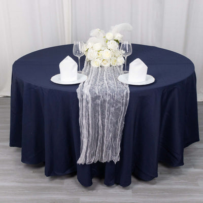 Elegant navy table setting with white flowers and decorative accents.