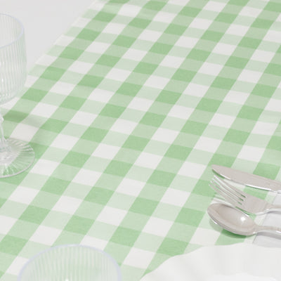 Green and white checkered tablecloth with glassware and cutlery.