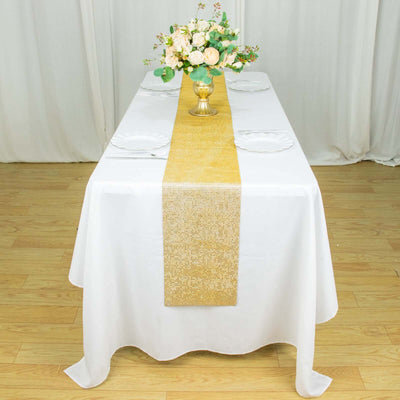 Elegant gold table runner on a white table setting with floral centerpiece.