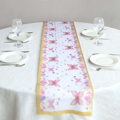 Butterfly print table runner on a dining table with plates and glasses.