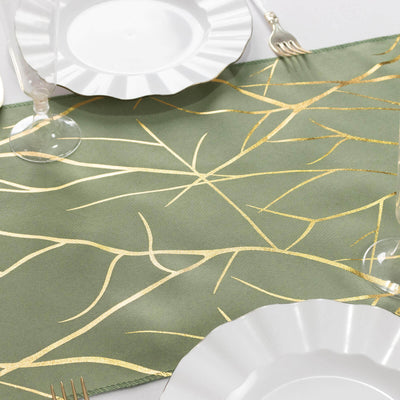 Elegant green table runner with gold leaf design, styled with white plates and glassware.