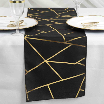Black table runner with gold geometric design on a dining table setting.