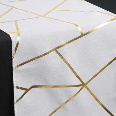 White table runner with gold geometric pattern on a black table.