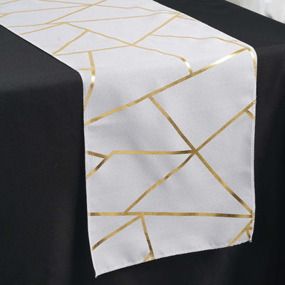 White table runner with gold geometric pattern on a black table.