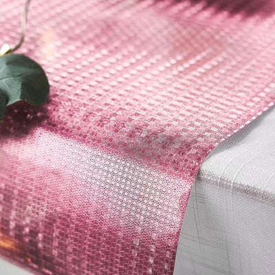 Pink honeycomb pattern table runner on a white table.