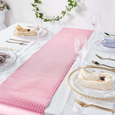 Pink textured table runner on a beautifully set dining table.