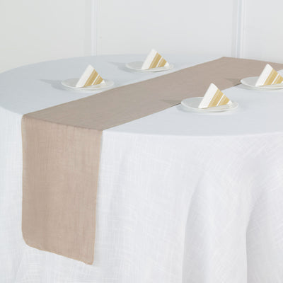 Beige table runner on a white table with folded napkins.