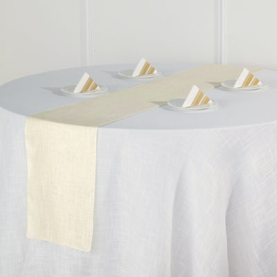 Cream table runner on a round table with folded napkins.