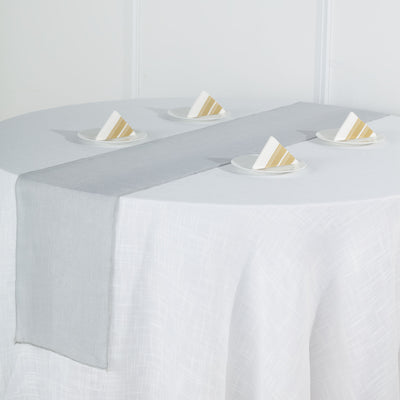 Gray table runner on a white table with decorative napkins.