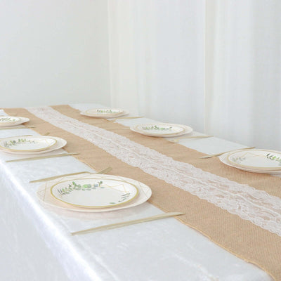 Elegant table setting with floral plates and lace runner.