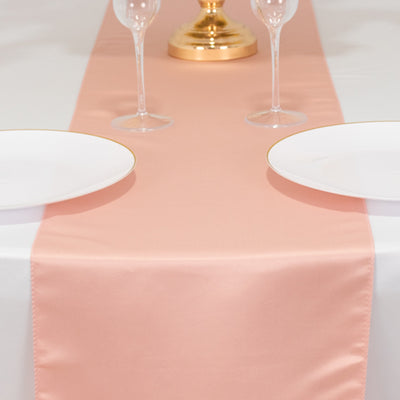 Peach satin table runner styled with plates and glasses