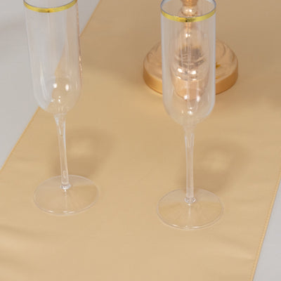 Elegant gold table runner with two clear champagne flutes.