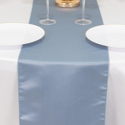 Blue table runner on a white table with plates and glasses.