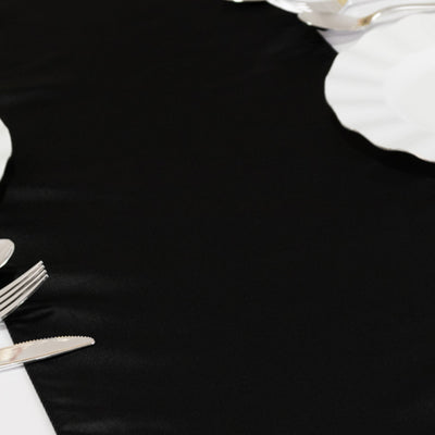 Black satin tablecloth on a dining table setting.