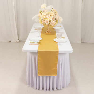 Elegant table setting with gold runner and floral centerpiece.