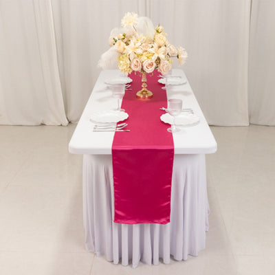 Elegant pink table runner on a white table with floral centerpiece.