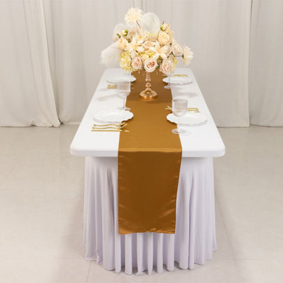 Elegant table setting with gold runner and floral centerpiece.