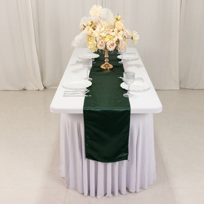 Elegant green table runner on a white table with floral centerpiece and dining setup.