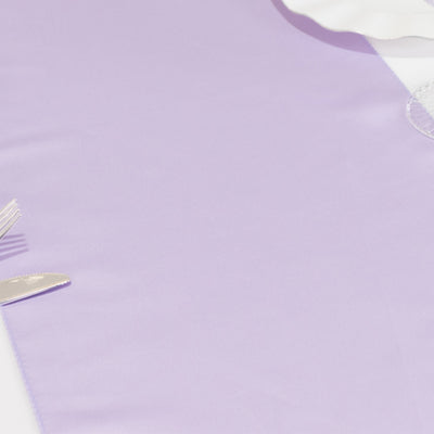 Purple tablecloth with silver cutlery on a plain background.