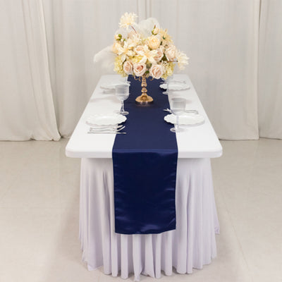 Elegant table setting with a navy runner and floral centerpiece.