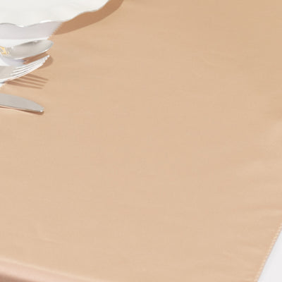 Elegant white plate with silver cutlery on a beige tablecloth.