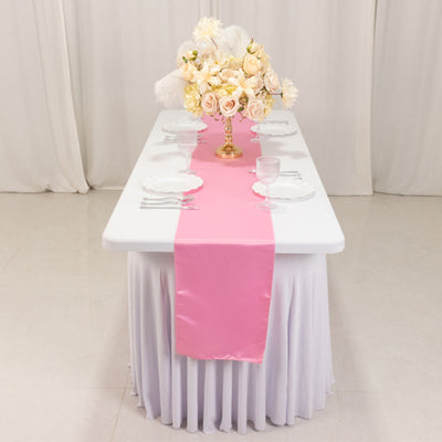 Elegant table setting with pink runner and floral centerpiece.
