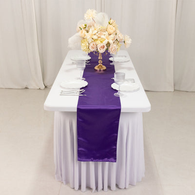 Elegant purple table runner on a beautifully set dining table with floral centerpiece.