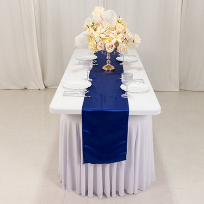 Elegant table setting with a navy satin runner and floral centerpiece.