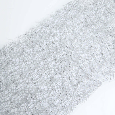 Silver beaded lace fabric on a white background