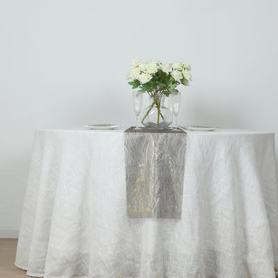 Elegant table setting with white tablecloth, floral centerpiece, and glassware.