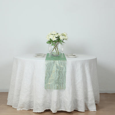 Table set with a green runner and white flowers in a vase.