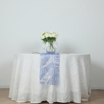 Elegant table setting with white flowers and blue runner on a round table.
