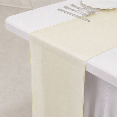 Elegant cream table runner on white tablecloth with silver cutlery