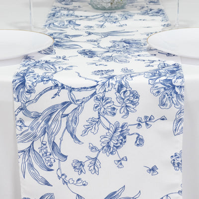 Blue floral table runner on a white table with plates on either side.