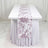 White table runner with mauve floral pattern on draped banquet table