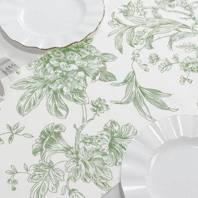 Floral patterned tablecloth with white plates on a light backdrop.