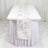 White floral table runner on a lavender round table with matching table skirt