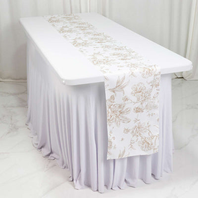 Elegant white table runner with floral gold design on draped tablecloth
