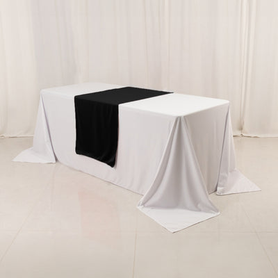 Table draped with white and black cloths in a studio setting