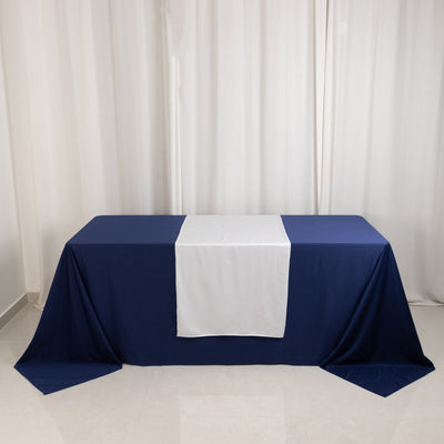 Navy blue tablecloth with white runner on a plain table