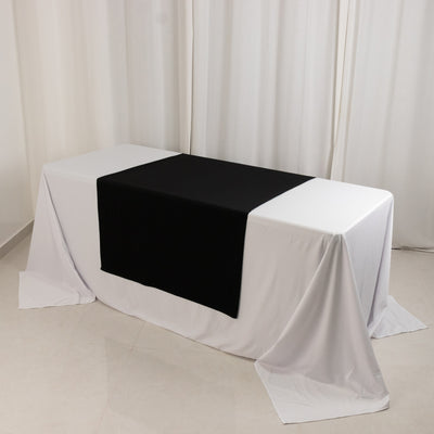 Black table runner on a white tablecloth in a studio setting.