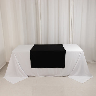 Black table runner on a white tablecloth in a minimalistic setting.