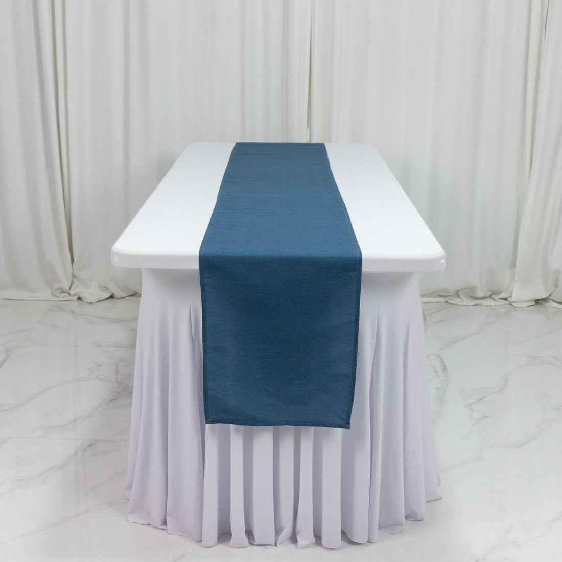 Blue table runner on a white tablecloth.