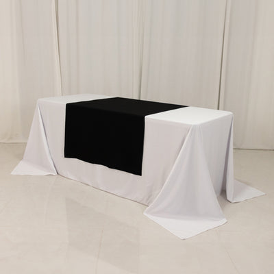 Black tablecloth on a white table in a studio setting.