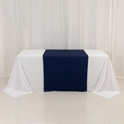 Navy table runner on a white tablecloth in a studio setting