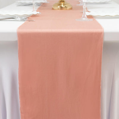 Peach table runner on a white table setting with elegant glassware.