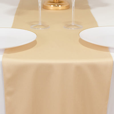 Elegant beige table runner on a dining table with white plates and glasses.