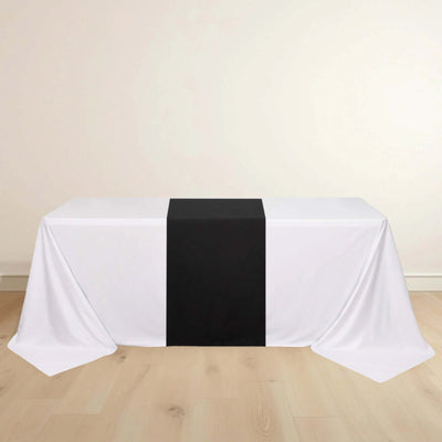 White tablecloth with a black center stripe on a wooden floor.