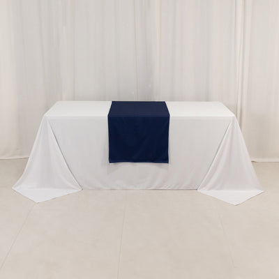 Navy table runner on a white tablecloth in a studio setting